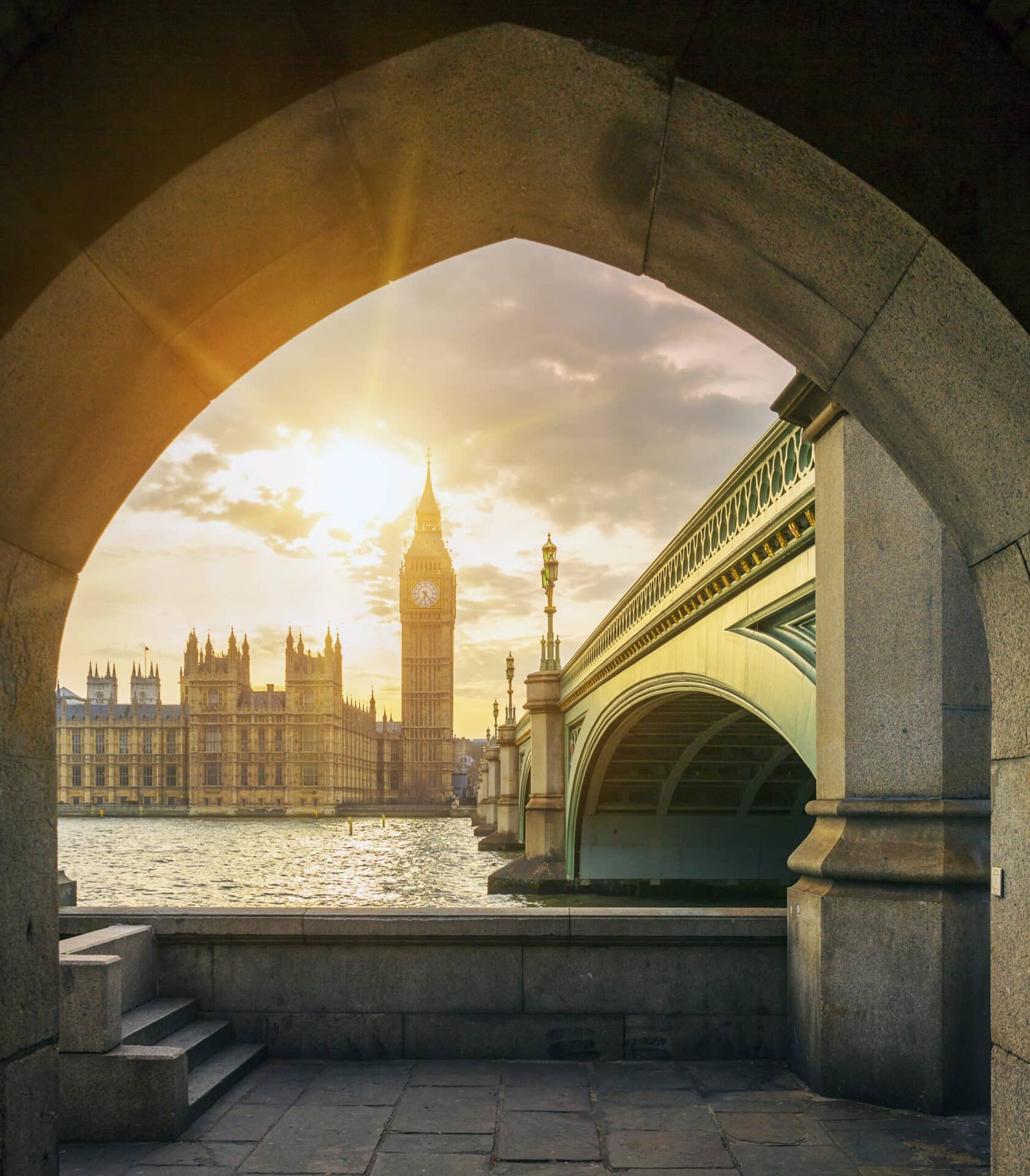 big ben with sun through pedestrian tunnel scaled